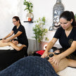 Pareja recibiendo masaje con piedras calientes en una sala de spa experience