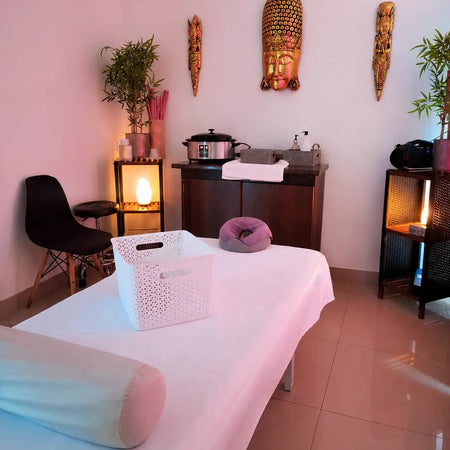 Sala de masajes de Spa Experience con camilla, iluminación cálida y decoración de Buda