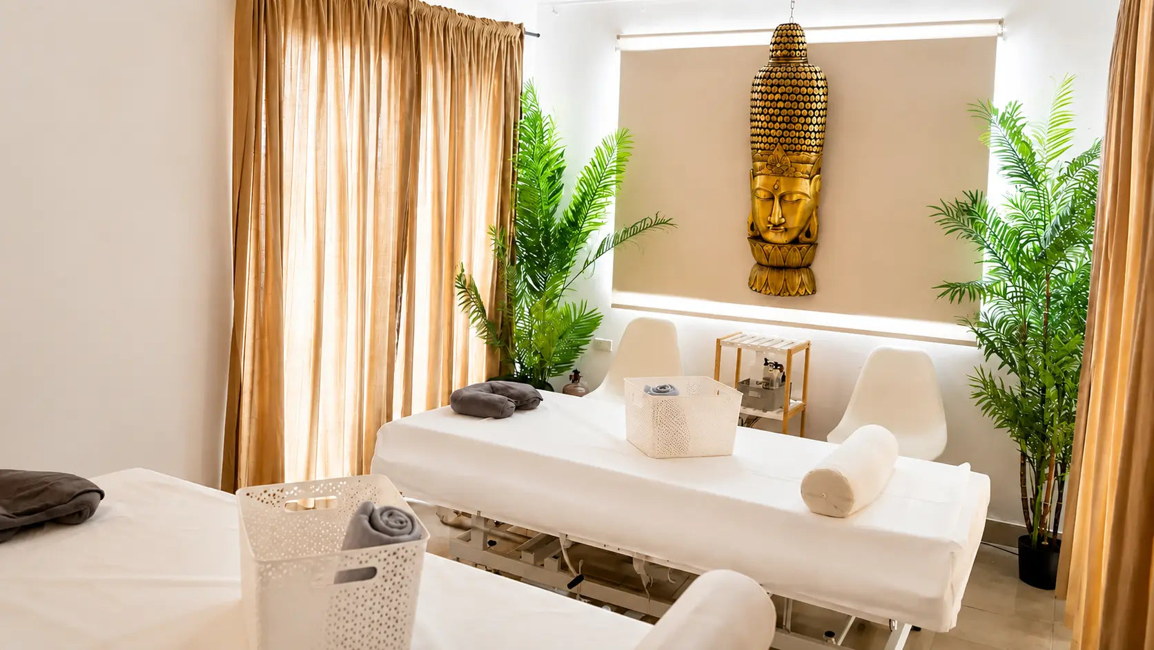 Sala doble de masajes de Spa Experience Antofagasta con dos camillas, plantas y decoración de Buda